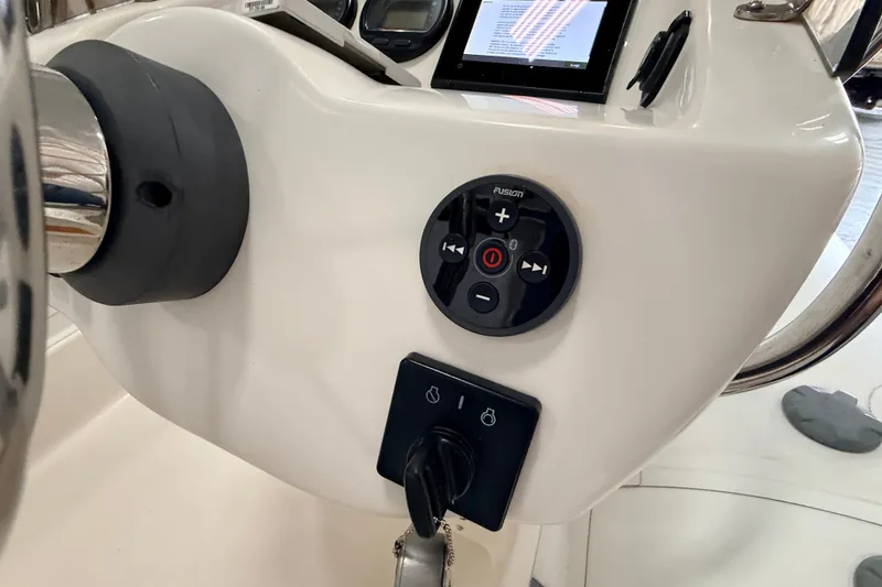 Slide: The Image of Control panel of 2014 Walker Bay Generation 450 DLX boat with steering wheel and audio controls. - 17