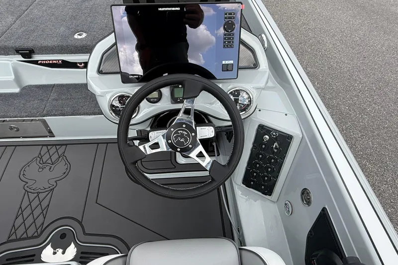 Slide: The Image of 2027 Phoenix 921 Elite X II boat dashboard with steering wheel and control panel. - 16