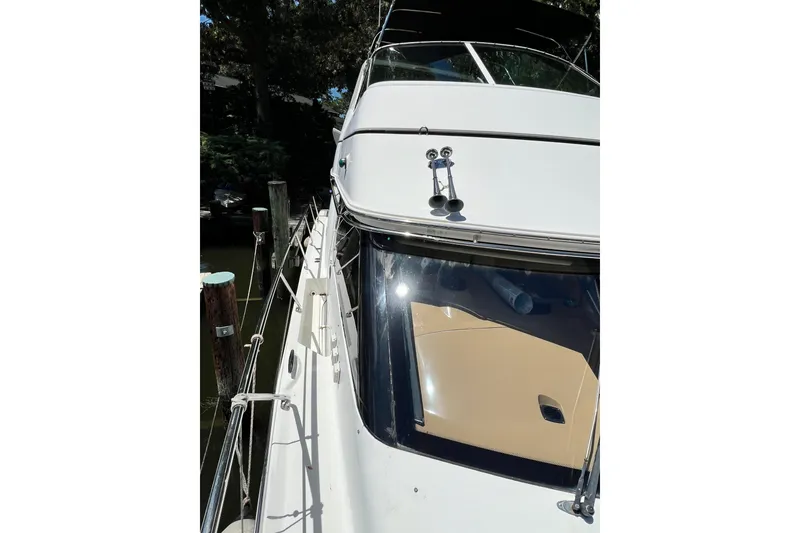 Slide: The Image of 2003 Carver 450 Voyager Pilothouse yacht docked, showcasing sleek design and polished exterior. - 58