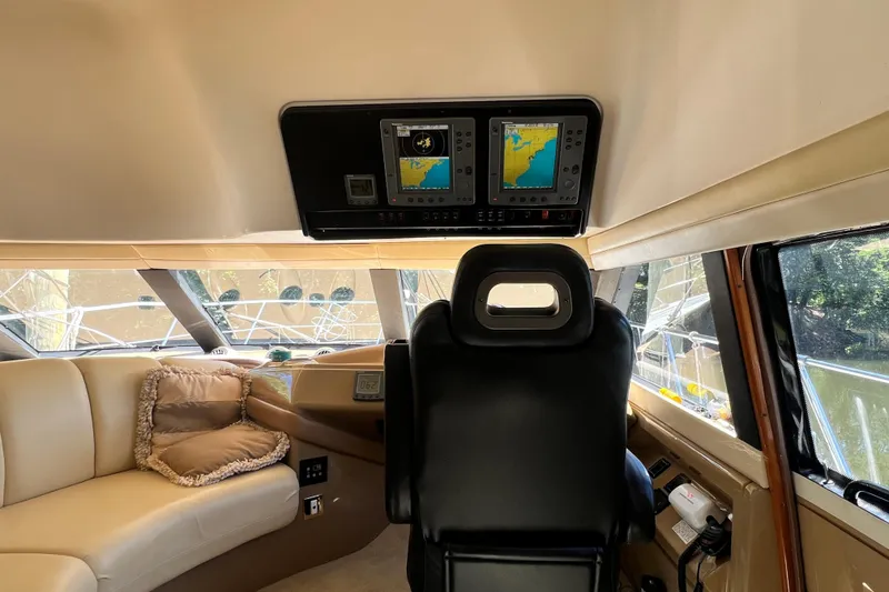 Slide: The Image of Interior of 2003 Carver 450 Voyager Pilothouse with navigation screens and plush seating. - 21