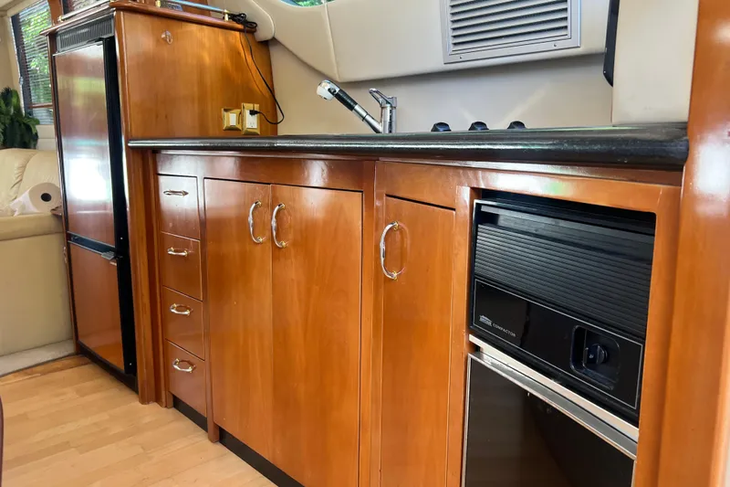 Slide: The Image of 2003 Carver 450 Voyager Pilothouse kitchen with wood cabinetry and modern appliances. - 26