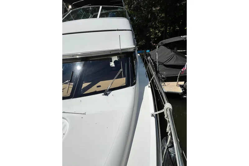 Slide: The Image of 2003 Carver 450 Voyager Pilothouse yacht docked, side view with railing and windows. - 57