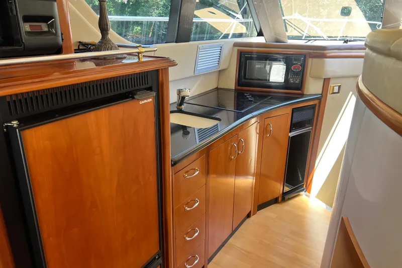 Slide: The Image of Luxurious kitchen interior of 2003 Carver 450 Voyager Pilothouse yacht with wood cabinetry. - 24