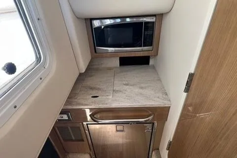 Slide: The Image of 2016 Formula 350 Crossover Bowrider I/O interior kitchenette with microwave and compact fridge. - 20