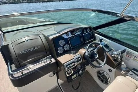 Slide: The Image of 2016 Formula 350 Crossover Bowrider I/O dashboard with steering wheel and control panel on water. - 12