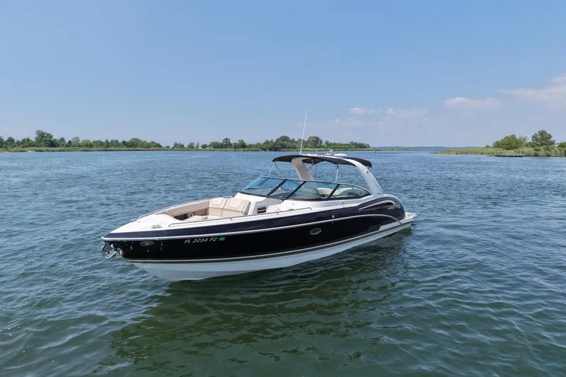 Slide: The Image of 2016 Formula 350 Crossover Bowrider I/O on serene lake under clear blue sky. - 1
