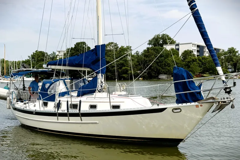 The Image of 2008 Pacific Seacraft 31 sailboat docked on a calm river with lush greenery. - 0