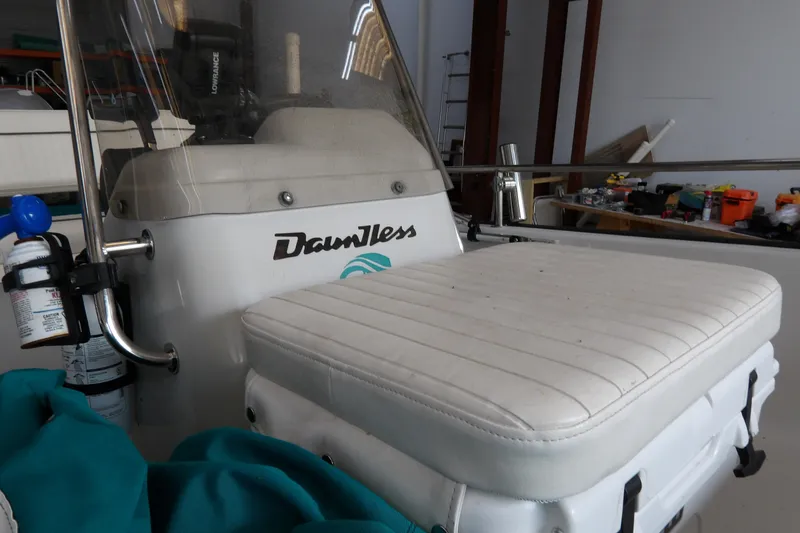 Slide: The Image of 1997 Boston Whaler Dauntless 13 boat interior with white seating and console. - 8