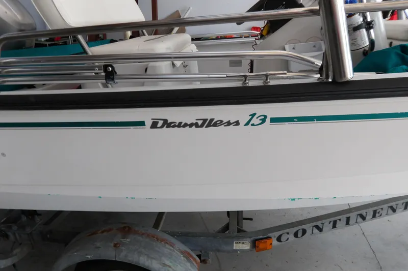 Slide: The Image of 1997 Boston Whaler Dauntless 13 boat on trailer, side view with logo visible. - 4