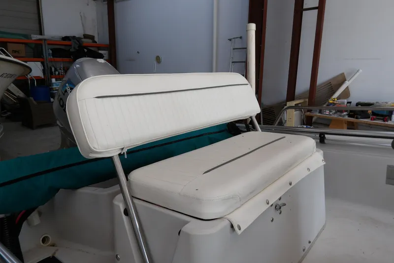 Slide: The Image of 1997 Boston Whaler Dauntless 13 boat interior with white seating in a garage setting. - 5