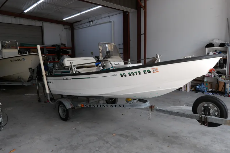 Slide: The Image of 1997 Boston Whaler Dauntless 13 boat on trailer in a garage setting. - 3