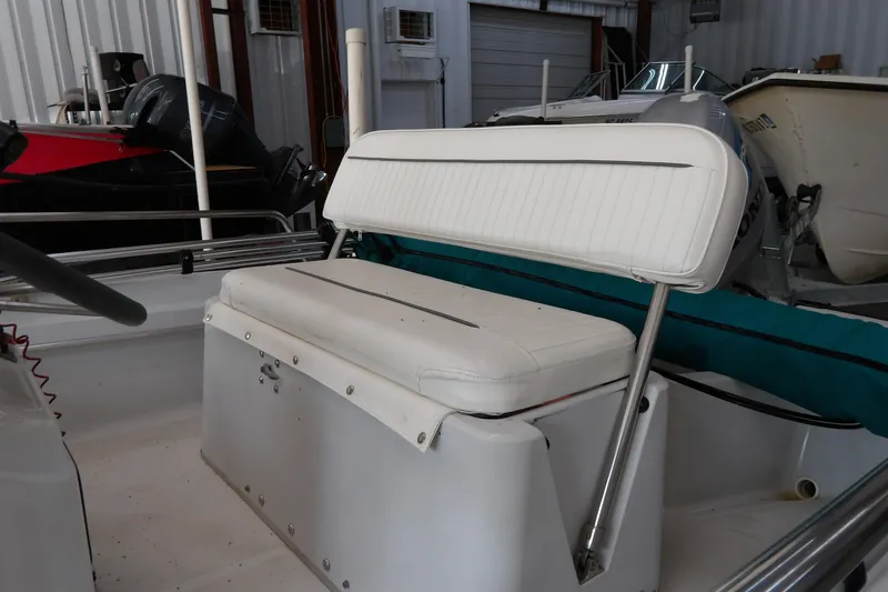 Slide: The Image of 1997 Boston Whaler Dauntless 13 boat interior with white seating in storage facility. - 13