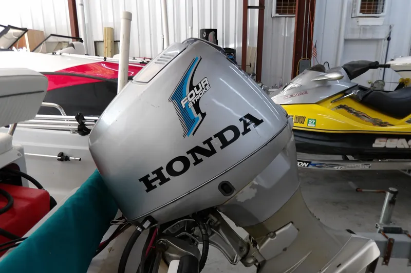 Slide: The Image of Honda outboard motor on a 1997 Boston Whaler Dauntless 13 boat in storage. - 15