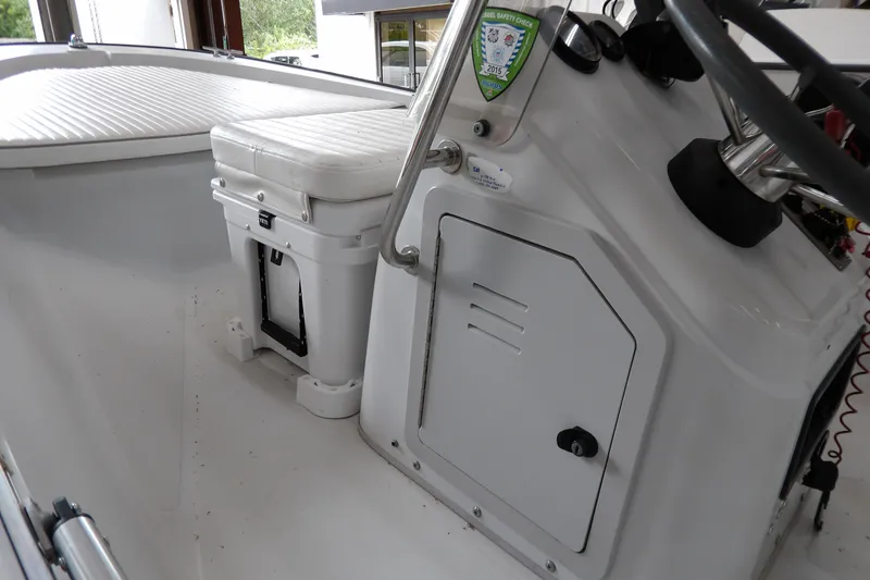 Slide: The Image of 1997 Boston Whaler Dauntless 13 interior, featuring helm and seating area with storage. - 10