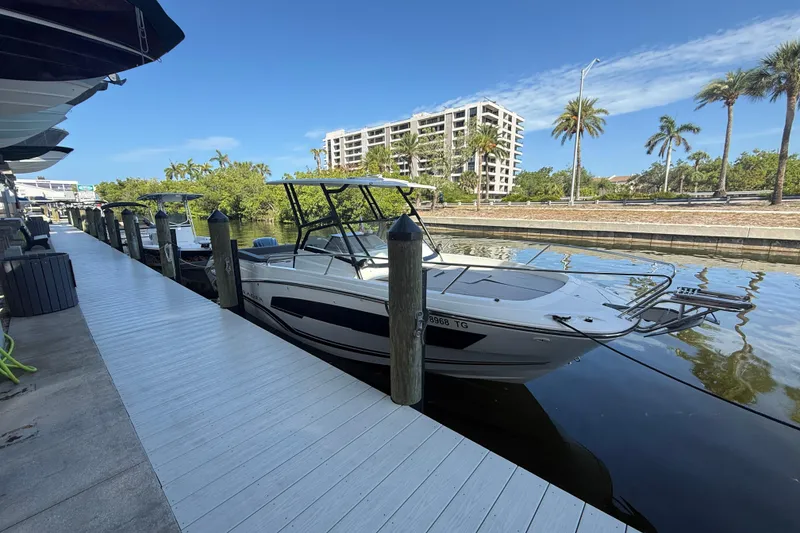The Image of 2020 Jeanneau Leader 7.5 CC docked by a waterfront boardwalk with palm trees. - 0