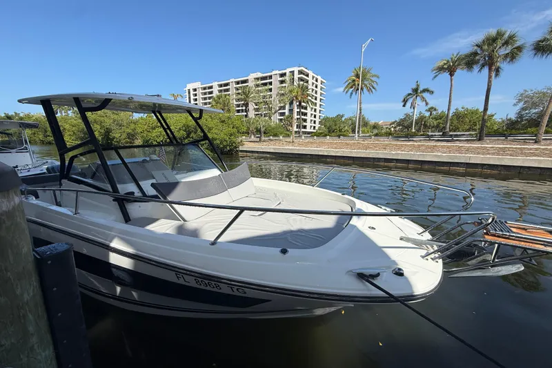 Slide: The Image of 2020 Jeanneau Leader 7.5 CC boat docked near palm trees and buildings. - 29