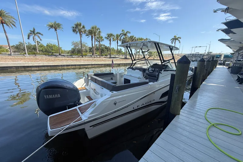Slide: The Image of 2020 Jeanneau Leader 7.5 CC boat docked, featuring Yamaha engine, palm trees in background. - 35