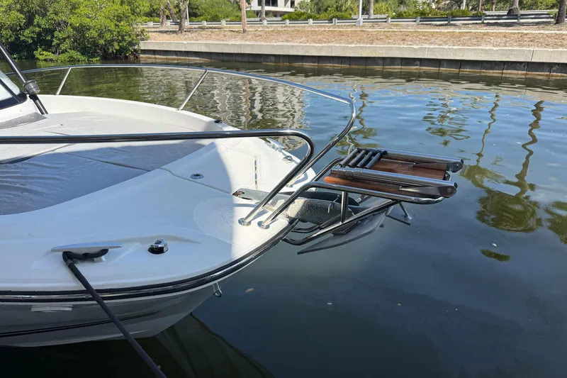 Slide: The Image of 2020 Jeanneau Leader 7.5 CC boat docked, featuring a sleek bow and swim ladder. - 32