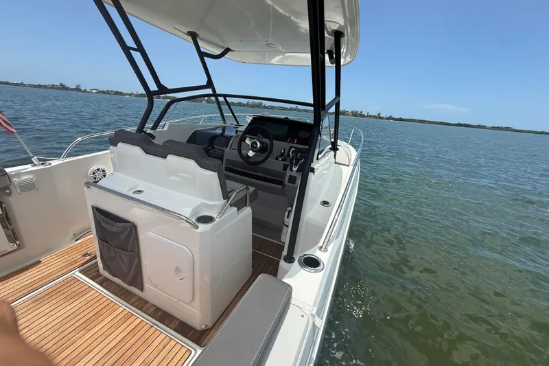 Slide: The Image of 2020 Jeanneau Leader 7.5 CC boat interior with steering wheel, on calm water. - 21