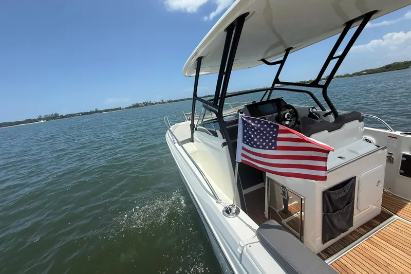 Slide: The Image of 2020 Jeanneau Leader 7.5 CC boat cruising on a sunny day with American flag. - 20
