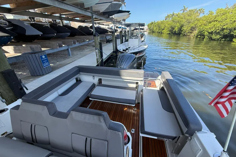Slide: The Image of 2020 Jeanneau Leader 7.5 CC boat docked, featuring spacious seating and American flag. - 33