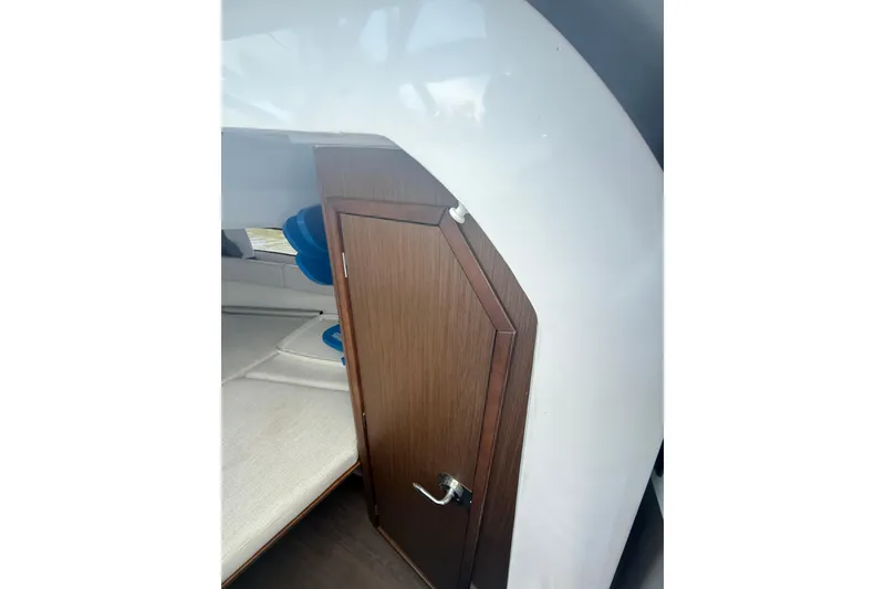 Slide: The Image of Interior cabin view of 2020 Jeanneau Leader 7.5 CC boat, featuring wooden door and seating. - 15
