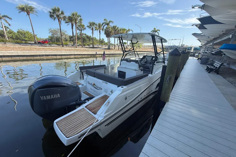 Slide: The Image of 2020 Jeanneau Leader 7.5 CC boat docked with Yamaha engine, palm trees in background. - 37