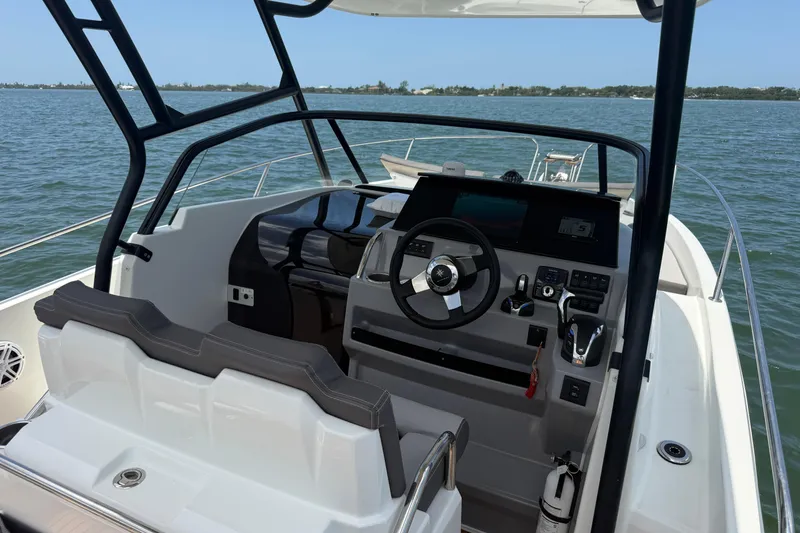 Slide: The Image of 2020 Jeanneau Leader 7.5 CC boat cockpit with steering wheel and controls on open water. - 19