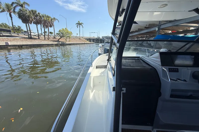 Slide: The Image of 2020 Jeanneau Leader 7.5 CC boat docked by a scenic waterfront with palm trees. - 28