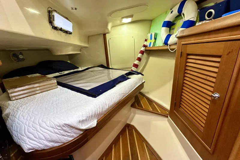 Slide: The Image of Cozy cabin interior of 2006 Island Packet 440 sailboat with bed and wooden cabinetry. - 53