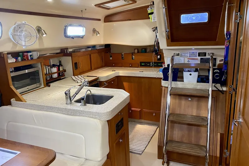 Slide: The Image of Interior of a 2006 Island Packet 440 yacht featuring a well-equipped kitchen area. - 38