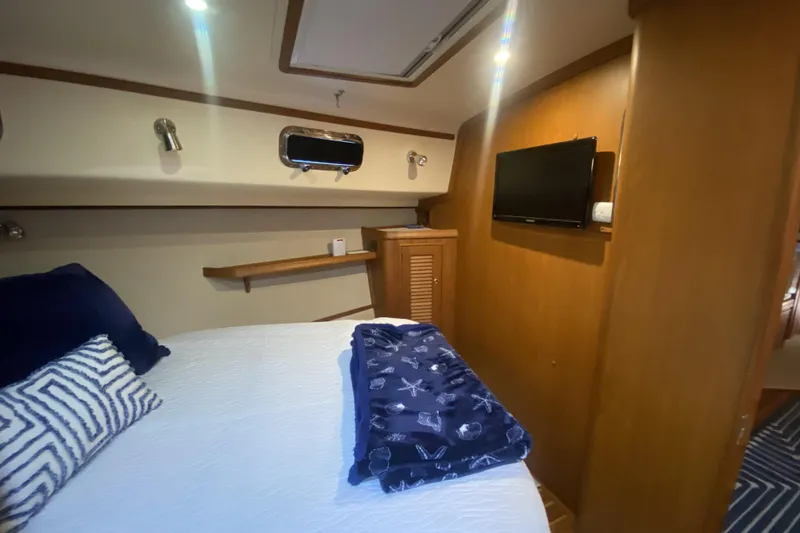 Slide: The Image of Cozy cabin interior of 2006 Island Packet 440 yacht with bed, TV, and nautical decor. - 47