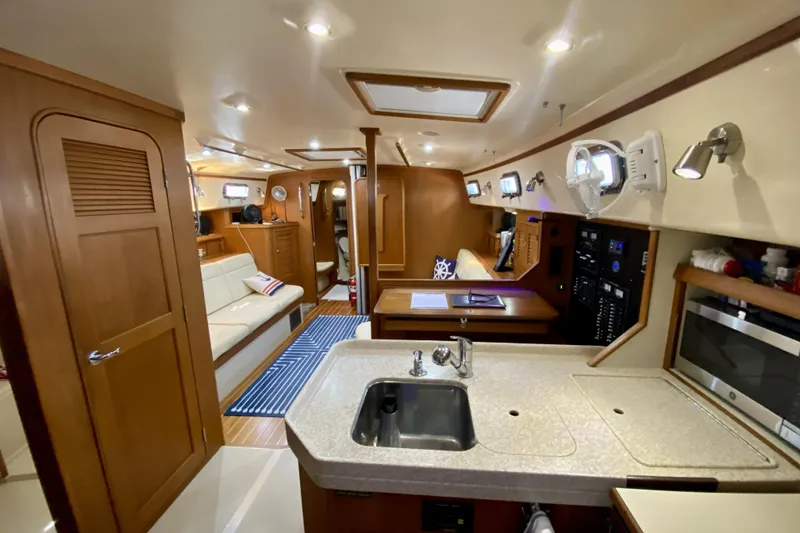 Slide: The Image of Interior of 2006 Island Packet 440 yacht, featuring a cozy kitchen and living area. - 39