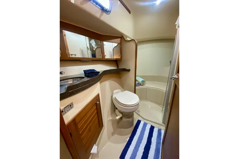 Slide: The Image of Bathroom interior of 2006 Island Packet 440 yacht, featuring shower, toilet, and striped rug. - 49