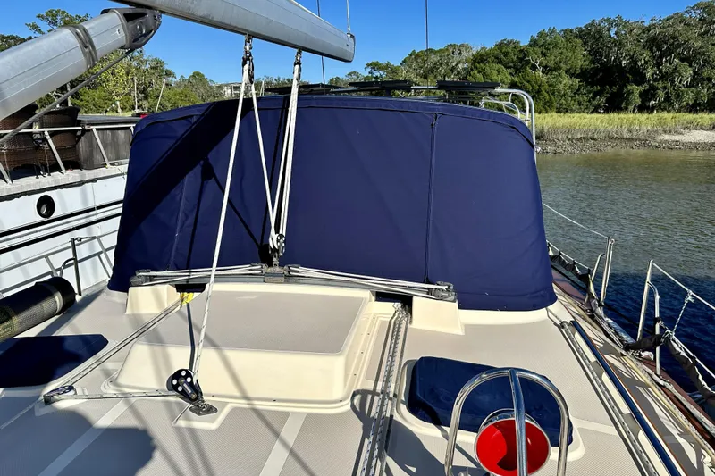 Slide: The Image of 2006 Island Packet 440 sailboat deck with blue canvas cover and scenic water view. - 19