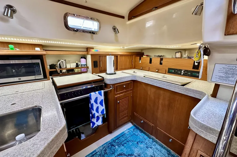 Slide: The Image of 2006 Island Packet 440 yacht kitchen with modern appliances and wooden cabinetry. - 40