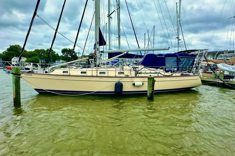 Slide: The Image of 2006 Island Packet 440 sailboat docked in a marina under cloudy skies. - 12