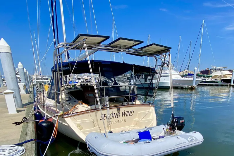 Slide: The Image of 2006 Island Packet 440 sailboat docked with solar panels and dinghy. - 2