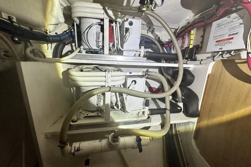Slide: The Image of Engine compartment of a 2006 Island Packet 440 sailboat, showcasing mechanical components and wiring. - 61