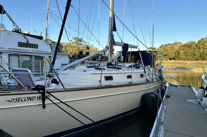 Slide: The Image of 2006 Island Packet 440 sailboat docked, named "Second Wind," with scenic background. - 23