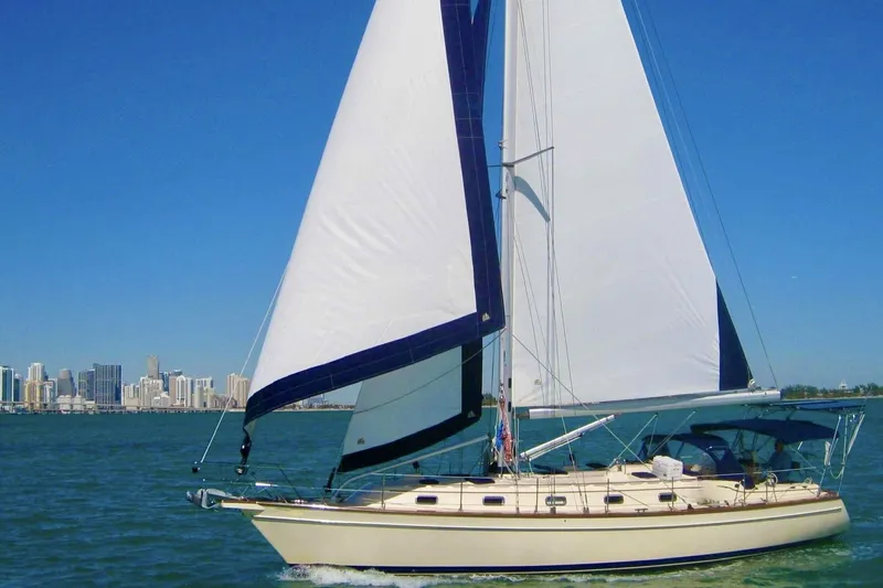 The Image of Sailing yacht Island Packet 440, 2006 model, cruising near a city skyline on a sunny day. - 0