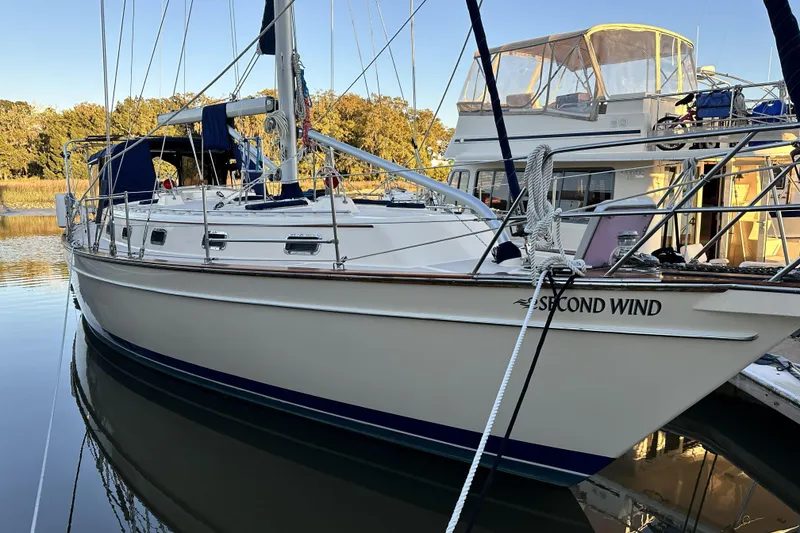 Slide: The Image of 2006 Island Packet 440 sailboat docked, named "Second Wind," with clear reflections on calm water. - 24