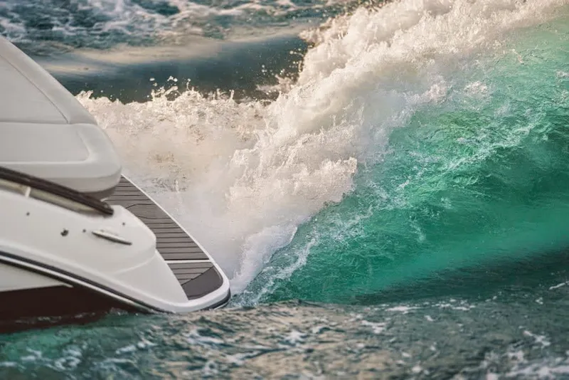 Slide: The Image of A Sea Ray SLX 260 Surf boat cuts through turquoise water, creating splashing waves. - 23