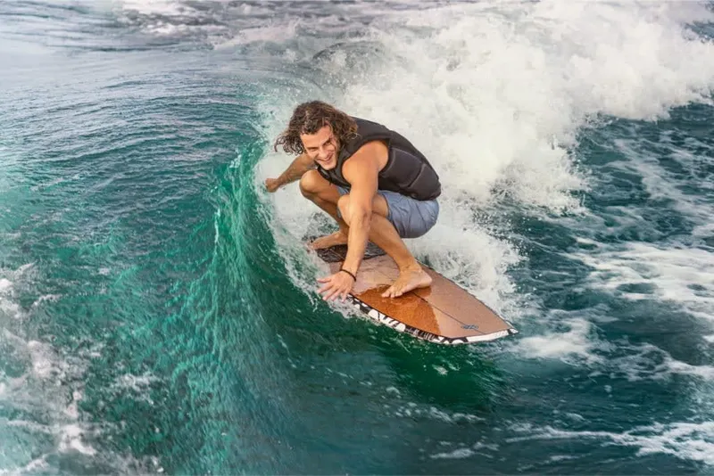Slide: The Image of A surfer rides a wave on a surfboard in clear blue water. - 10