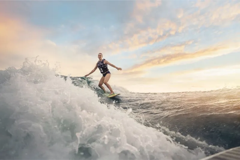Slide: The Image of A person surfing on a large wave at sunset. - 21