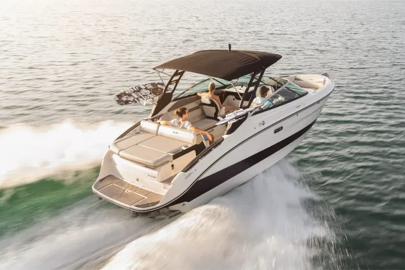 Slide: The Image of Sea Ray SLX 260 Surf 2026: Sleek motorboat with black canopy, speeding on calm water. - 2