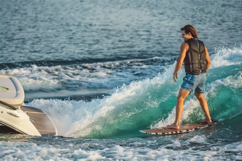 Slide: The Image of A man surfs on a wave behind a Sea Ray SLX 260 Surf boat. - 20