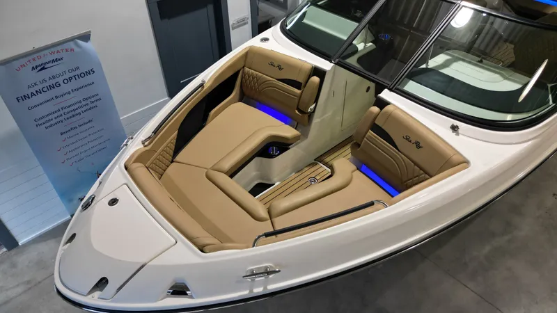 Slide: The Image of The image shows the interior of a 2027 Sea Ray SLX 280 boat with beige seats and blue lighting. - 24