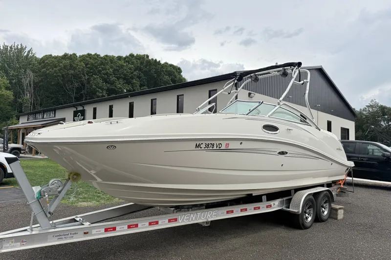 Slide: The Image of 2007 Sea Ray 260 Sundeck on trailer, parked outdoors near a building. - 2