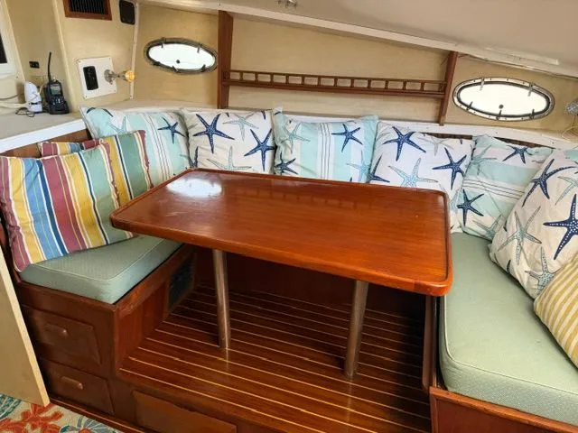 Slide: The Image of Interior of a 1990 Topaz Royale with a wooden table and star-patterned cushions. - 9